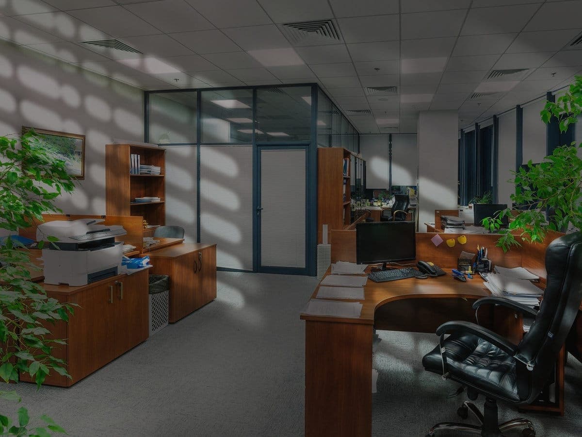 Intérieur d'un bureau d'entreprise avec postes de travail en bois, prêt pour un transfert coordonné